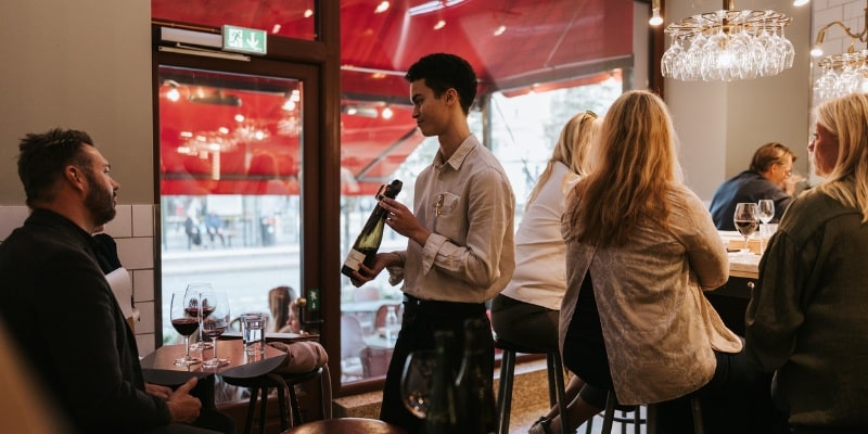 Sommelier som presenterar vin för gäster